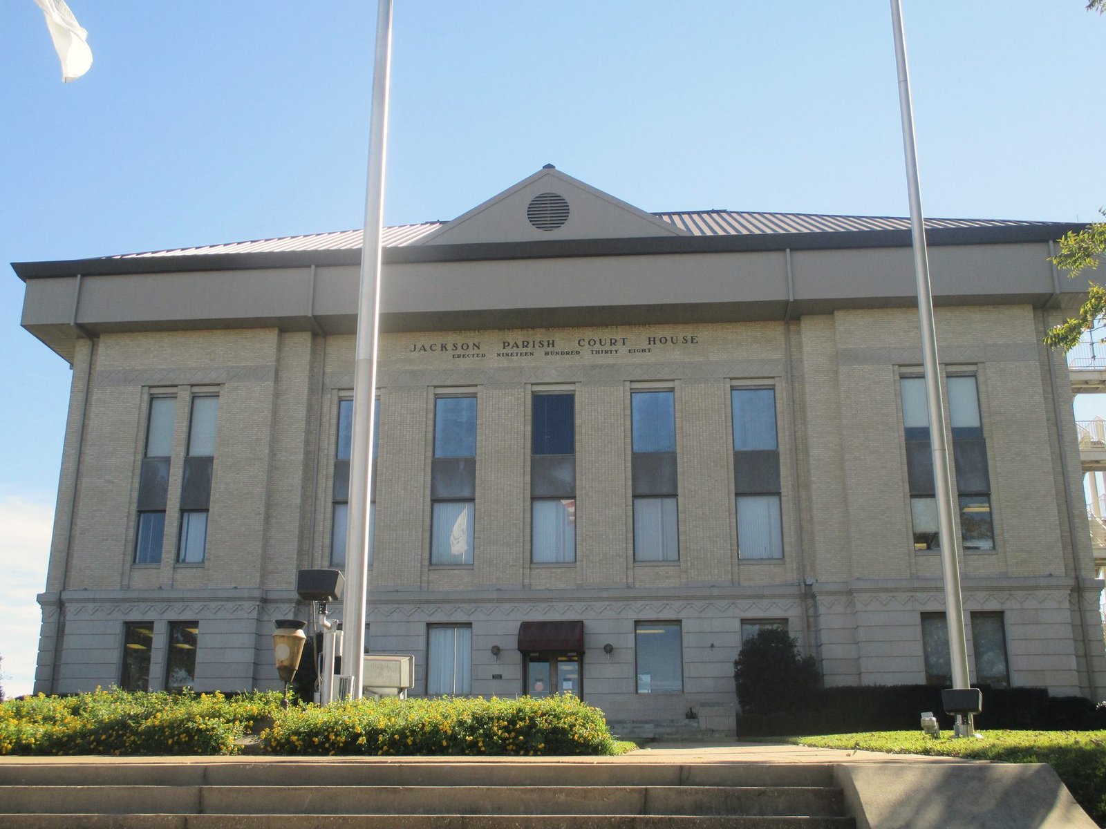 The restored brick Jackson Parish Courthouse with flagpoles in front