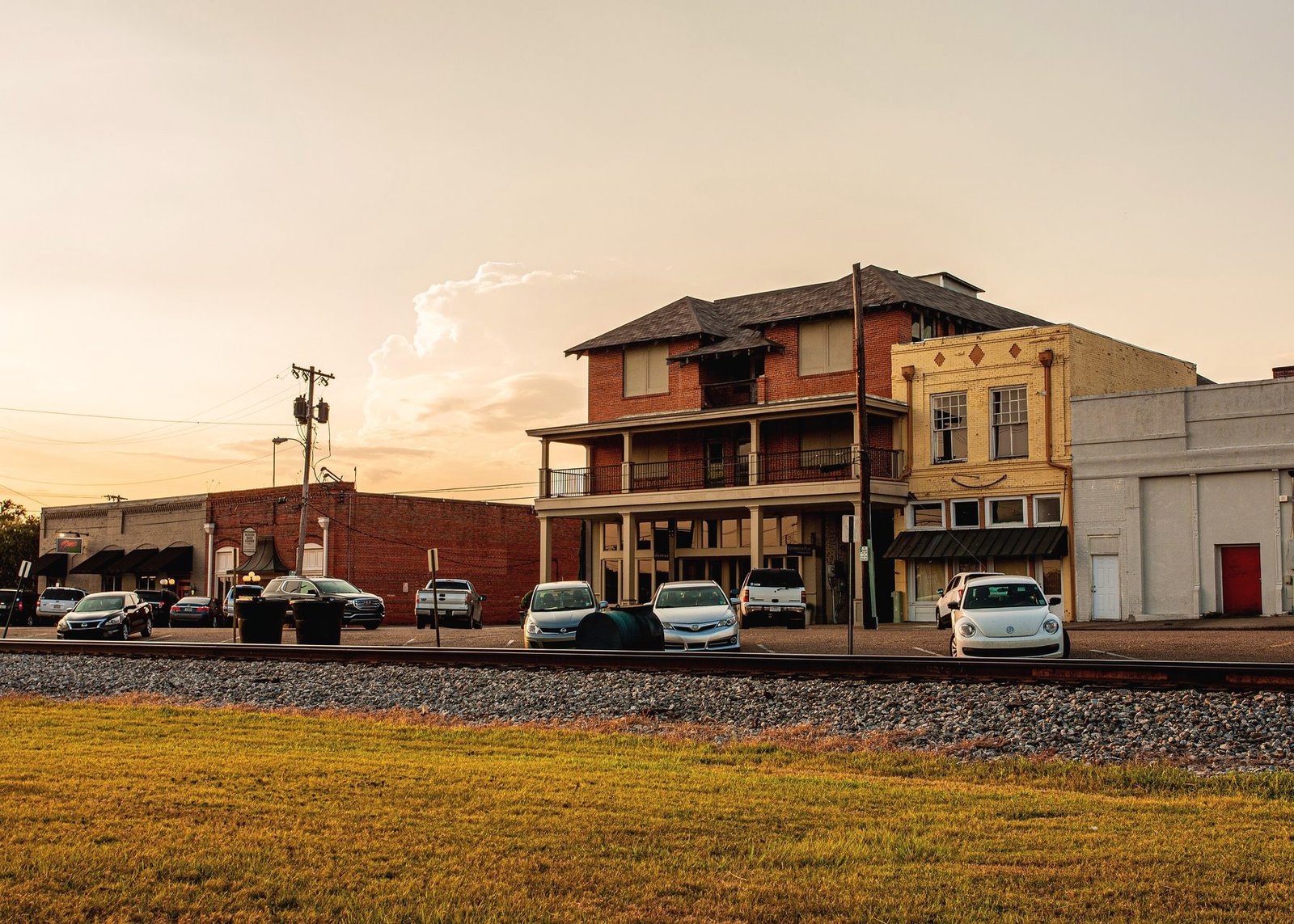 Brick storefronts in downtown Ruston at sunset beyond the railroad tracks